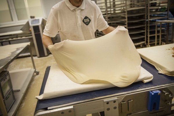 Strudelteilg welcher gezogen wird und auf ein Backblech kommt