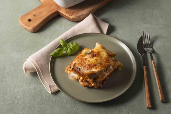 Brotlasagne auf einem grünen Teller auf dem Tisch