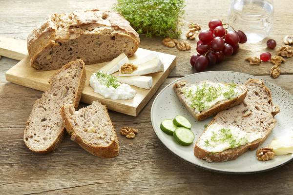 Haubis Walnussbrot auf einem Teller mit aufgeschnittenen Käse und Gemüse