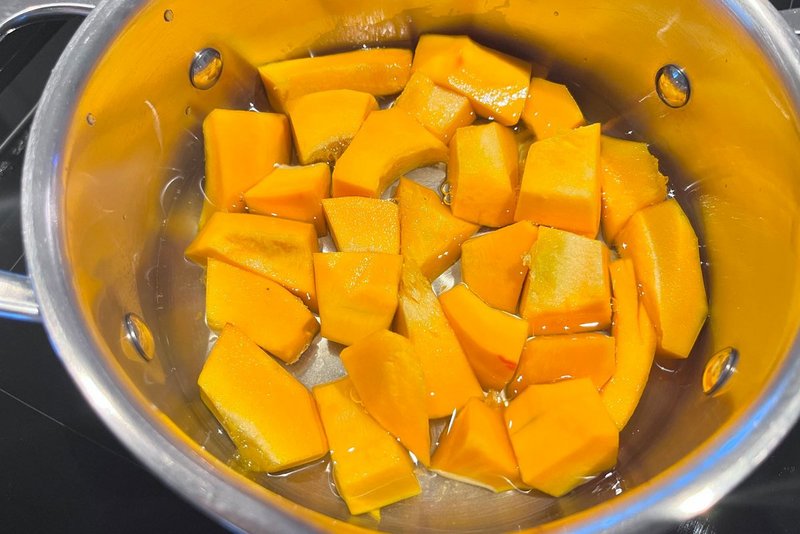 Kürbiswürfel im Topf mit Wasser