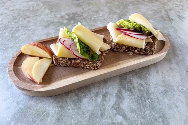 Vollkornbrot mit Käse, Salat, Radieschen und Obst