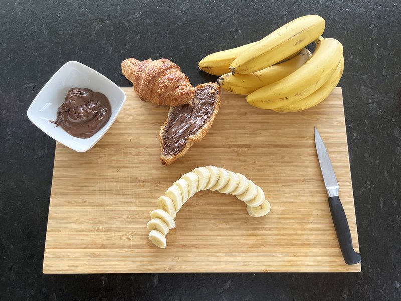 Banane aufgeschnitten und Haubis Croissant mit Nougat bestrichen